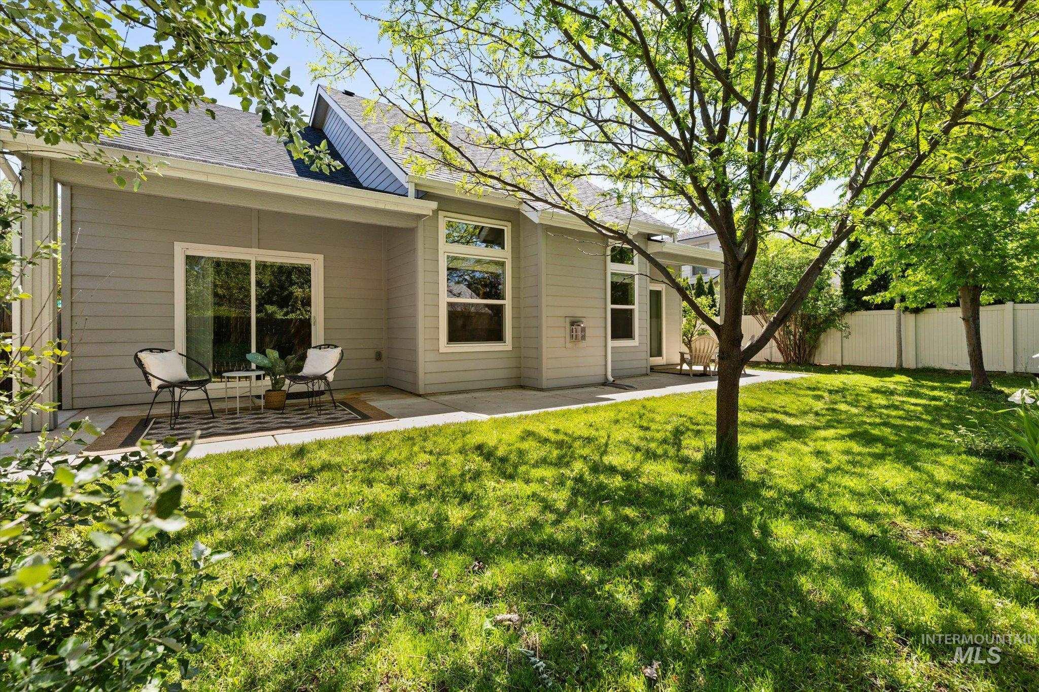 1915 South High Street Boise, ID 83706 - Photo 35 of 44 Expansive backyard featuring a green lawn, mature trees, and a full-height privacy fence