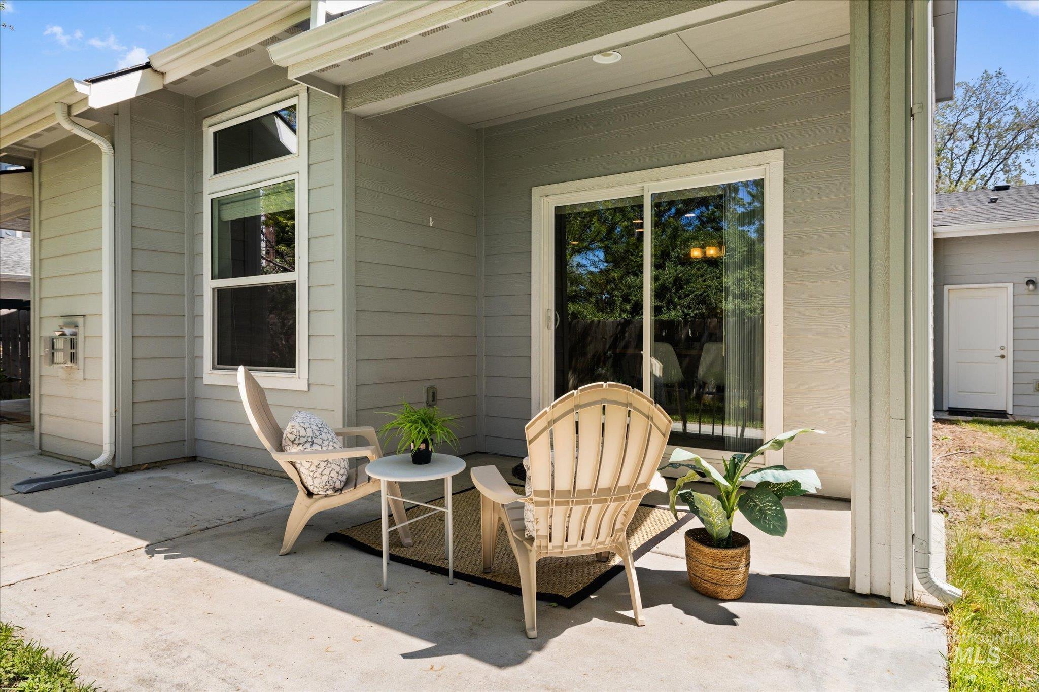 1915 South High Street Boise, ID 83706 - Photo 38 of 44 Concrete patio with covered area, light gray siding, white vertical window, and sliding glass door