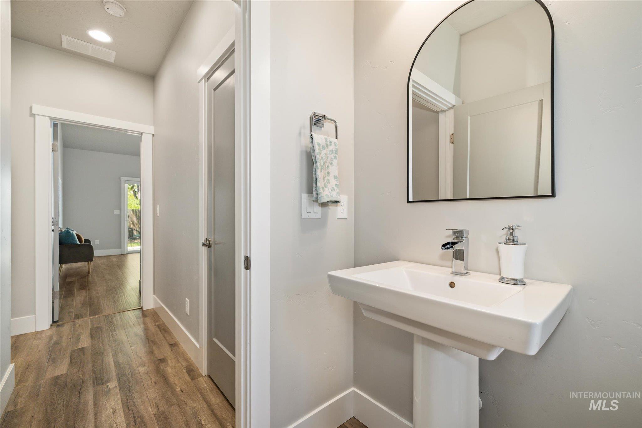 1915 South High Street Boise, ID 83706 - Photo 4 of 44 Pedestal sink with chrome faucet, complemented by an arched mirror with a black frame