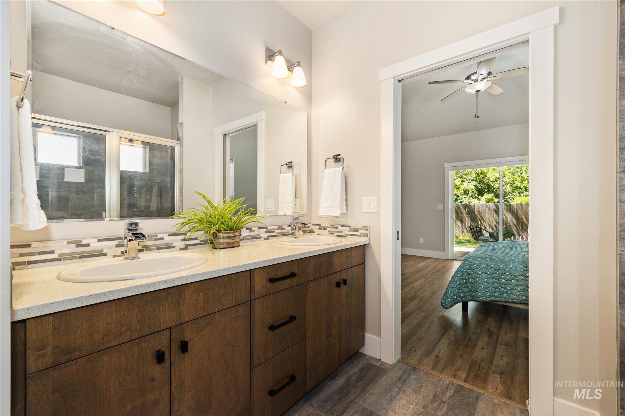 1915 South High Street Boise, ID 83706 - Photo 7 of 44 Dual vanity with wood-finish cabinetry, light-toned countertops, and a modern rectangular tile backsplash