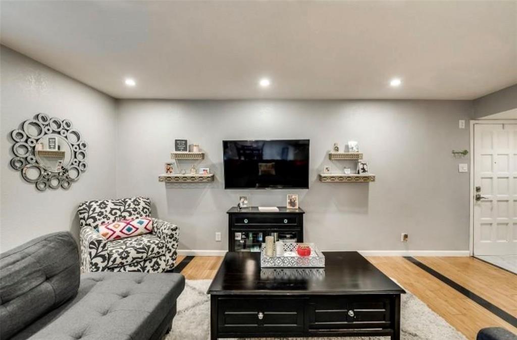 6026 Birchbrook Drive, Unit 119 Dallas, TX 75206 - Photo 3 of 13 a living room with furniture and a flat screen tv