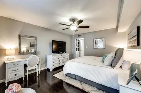 a spacious bedroom with a bed and a flat screen tv