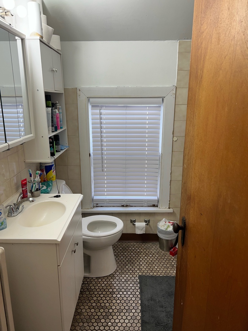1449 Main Street Crete, IL 60417 - Photo 3 of 4 a bathroom with a sink toilet and a window