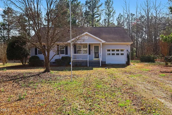 a view of a house with a yard covered with snow and trees