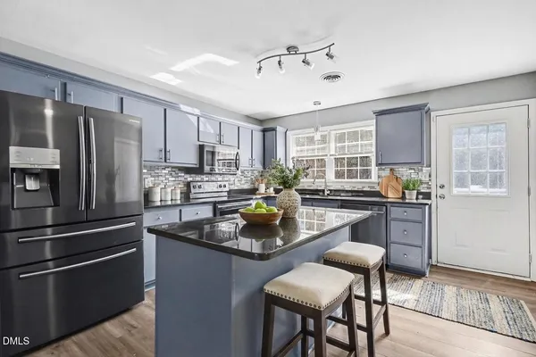 a kitchen with refrigerator cabinets dining table and chairs