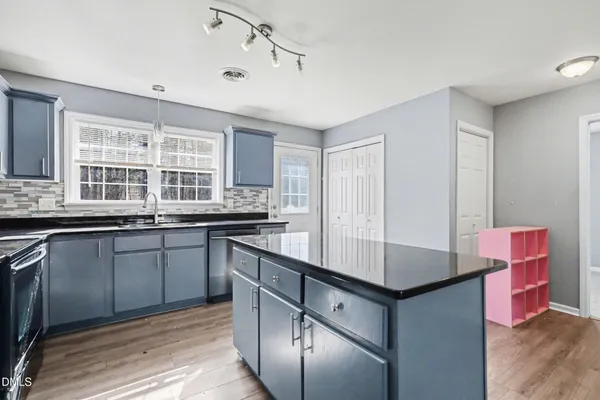 a kitchen with granite countertop a stove and cabinets