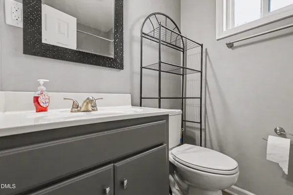 a bathroom with a sink a toilet and a mirror