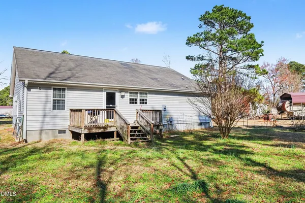 a view of a house with backyard and sitting area