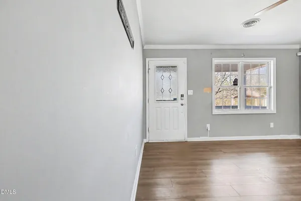 a view of a big room with wooden floor and windows