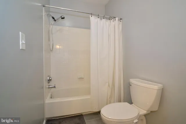 a white toilet sitting next to a bath tub