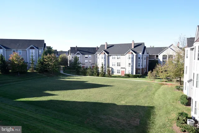 a view of a big house with a big yard and large trees