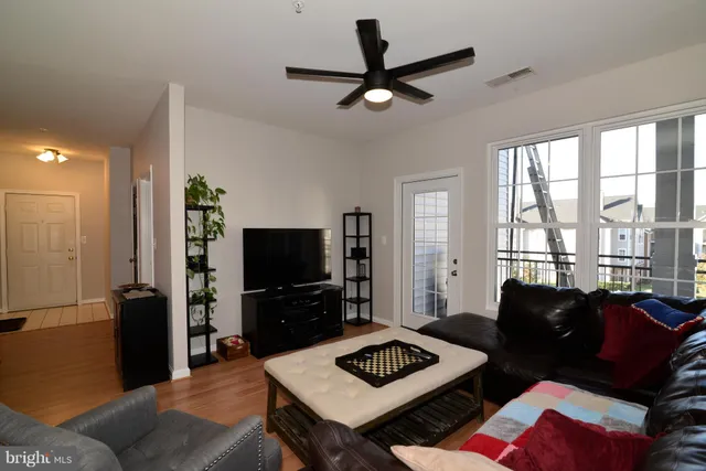 a living room with furniture a flat screen tv and a window