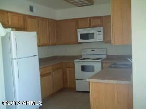 14097 South Berwick Road, Unit C Arizona City, AZ 85123 - Photo 3 of 8 a kitchen with a refrigerator sink and cabinets