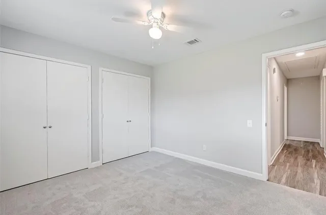 a view of an empty room with a ceiling fan
