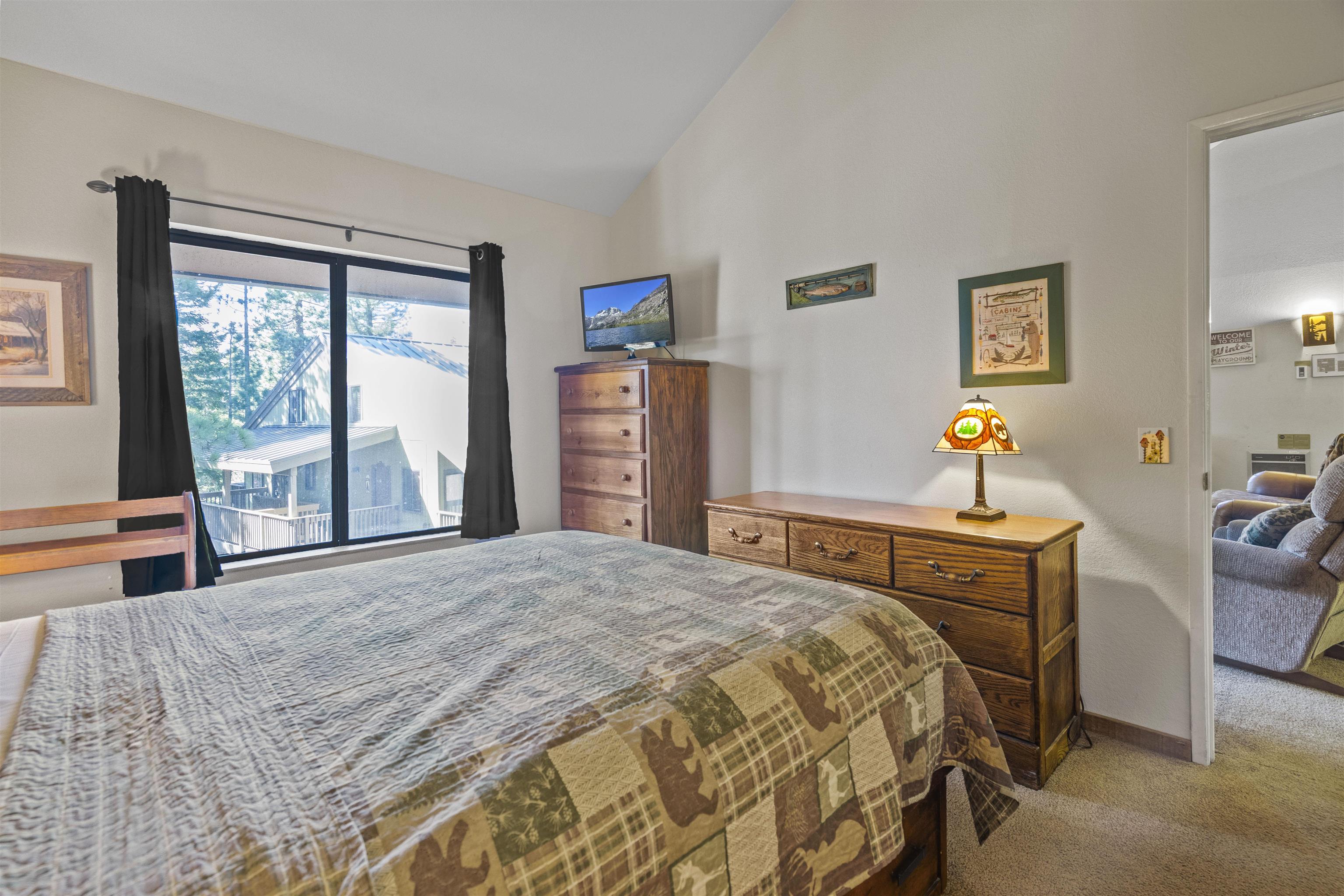153 Lake Mary Road, Unit 114 Mammoth Lakes, CA 93546 - Photo 9 of 22 Vaulted ceilings enhance this room featuring carpet flooring and a large window with exterior views