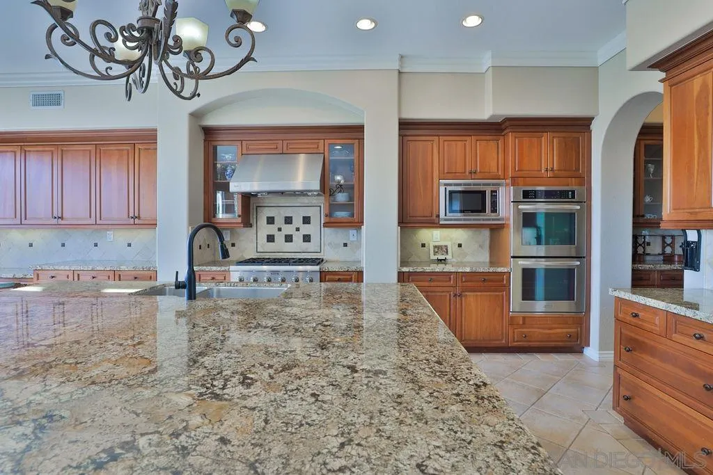 1375 Ravean Court Encinitas, CA 92024 - Photo 31 of 73 a kitchen with stainless steel appliances granite countertop a stove a sink and a refrigerator