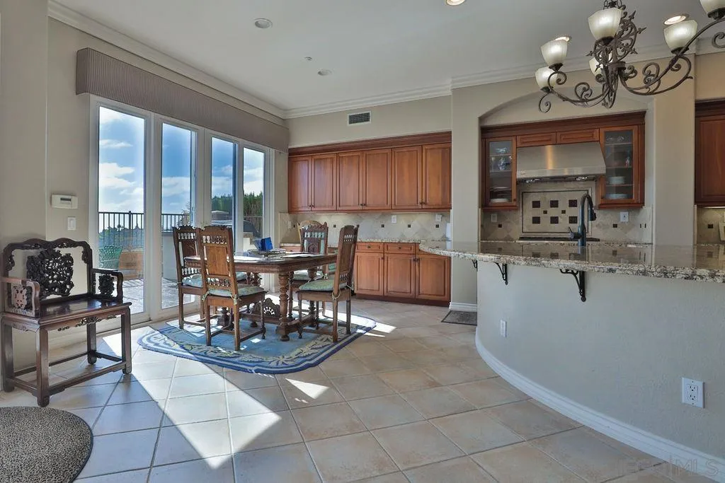1375 Ravean Court Encinitas, CA 92024 - Photo 32 of 73 a living room with granite countertop furniture a dining table a large window and kitchen view