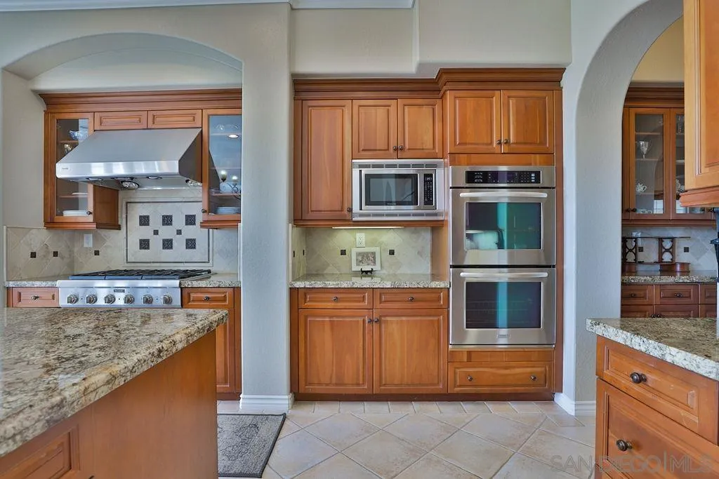 1375 Ravean Court Encinitas, CA 92024 - Photo 34 of 73 a kitchen with stainless steel appliances granite countertop a stove microwave and cabinets