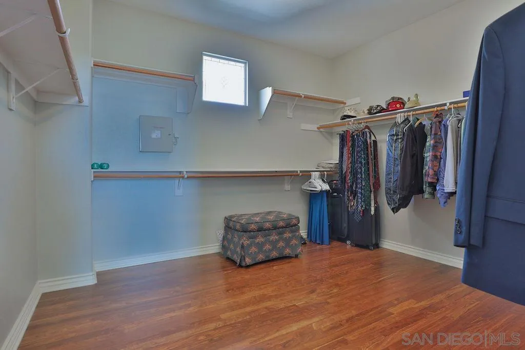 1375 Ravean Court Encinitas, CA 92024 - Photo 55 of 73 a room with a refrigerator and a wooden floor