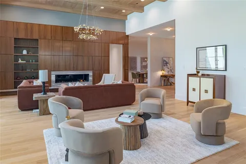 a living room with furniture a fireplace and a chandelier