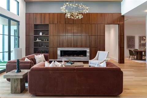 a living room with furniture a fireplace and a chandelier