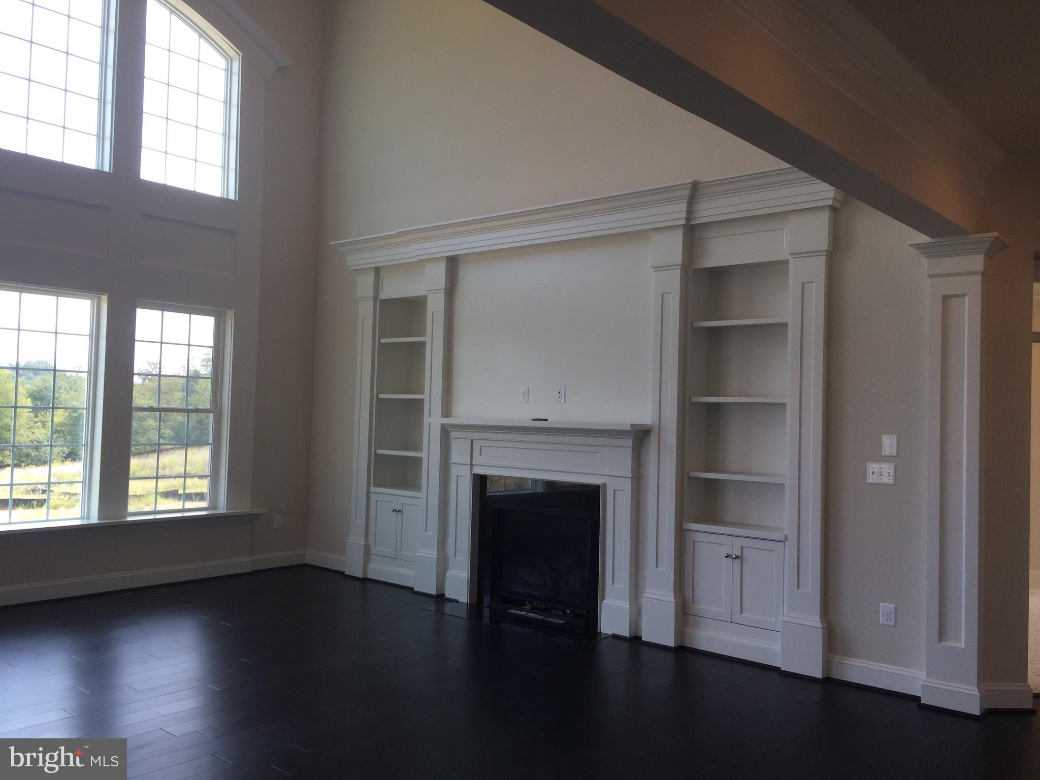 515 Parkland Road Eldersburg, MD 21784 - Photo 4 of 18 an empty room with wooden floor fireplace and windows