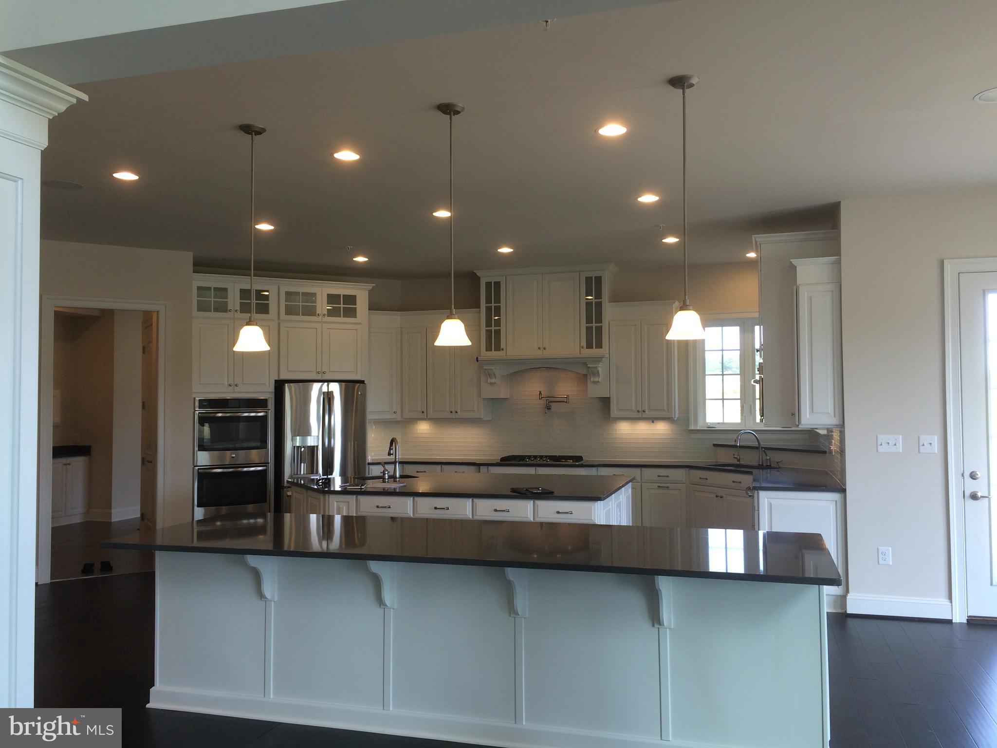 515 Parkland Road Eldersburg, MD 21784 - Photo 6 of 18 a large kitchen with kitchen island granite countertop a large counter top stainless steel appliances and cabinets