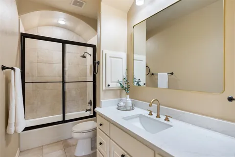 a bathroom with a toilet a sink and a large mirror