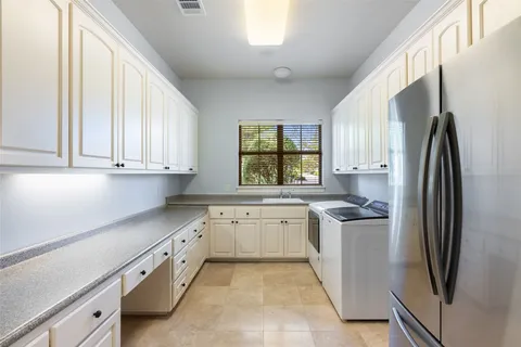 a kitchen with stainless steel appliances granite countertop a refrigerator sink and stove