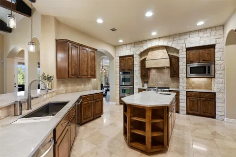 a kitchen with stainless steel appliances granite countertop a sink stove and refrigerator