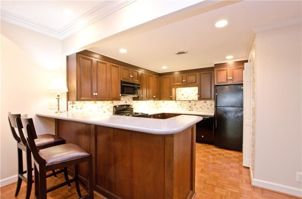 2734 Peachtree Road Northwest, Unit C404 Atlanta, GA 30305 - Photo 8 of 19 a kitchen with a sink and chairs