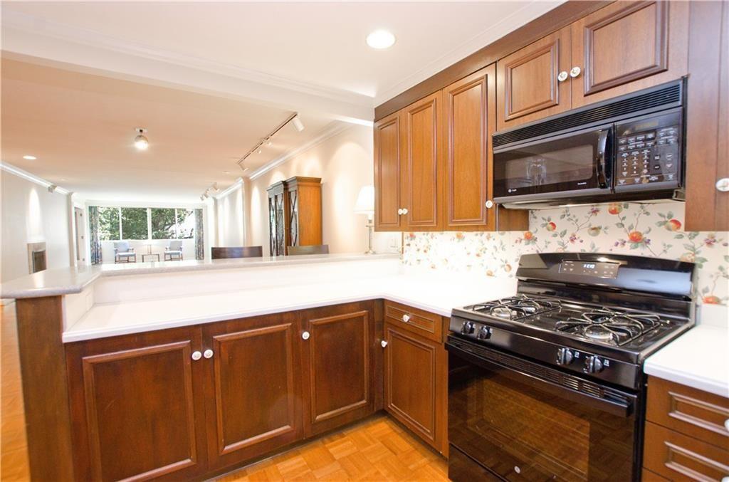 2734 Peachtree Road Northwest, Unit C404 Atlanta, GA 30305 - Photo 9 of 19 a kitchen with stainless steel appliances granite countertop a stove and a microwave