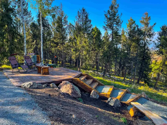 a view of a patio with table and chairs and potted plants with wooden fence