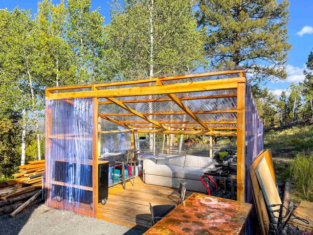 a view of swimming pool with lawn chairs and large trees