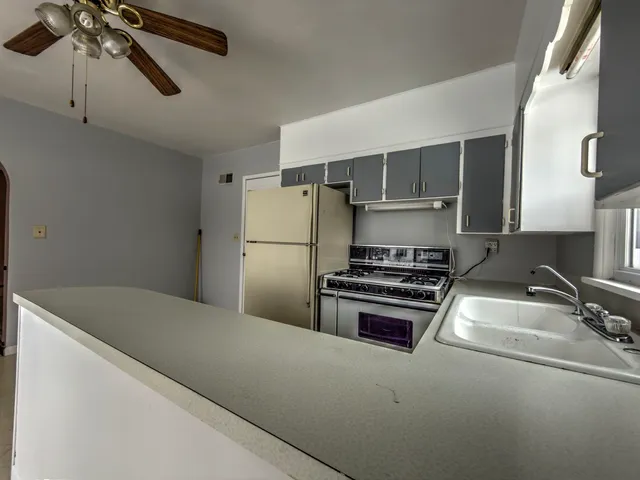 a kitchen with a refrigerator and a stove top oven