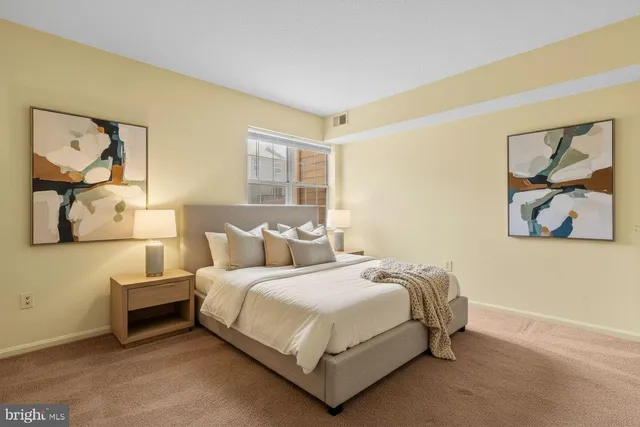 a bedroom with a bed and painting on the wall