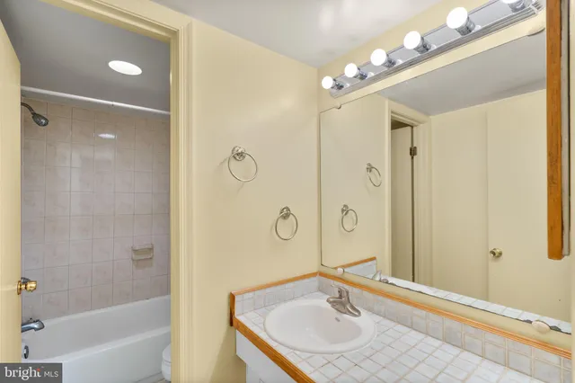 a bathroom with a sink a toilet a mirror and shower