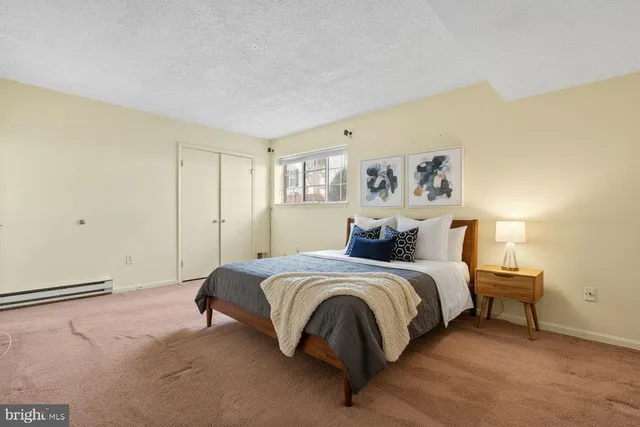 a spacious bedroom with a bed and a lamp