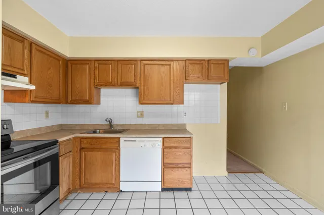 a kitchen with a sink a stove top oven and cabinets