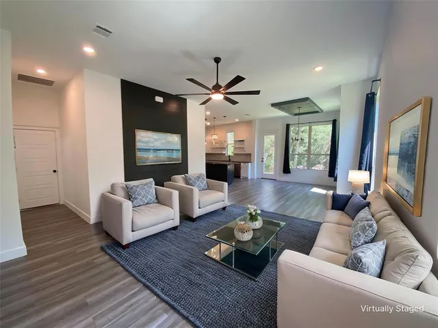 a living room with couches a coffee table and a flat screen tv