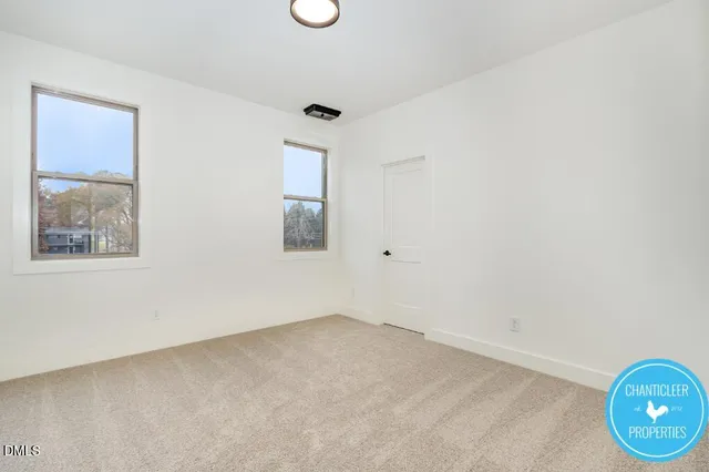 an empty room with wooden floor and window