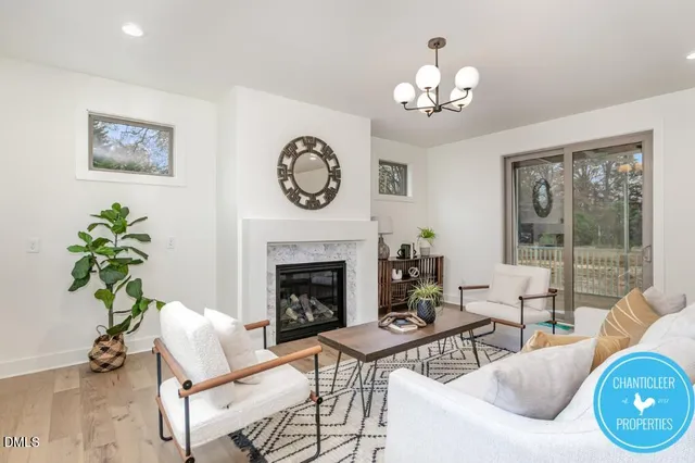 a living room with furniture a chandelier and a fireplace