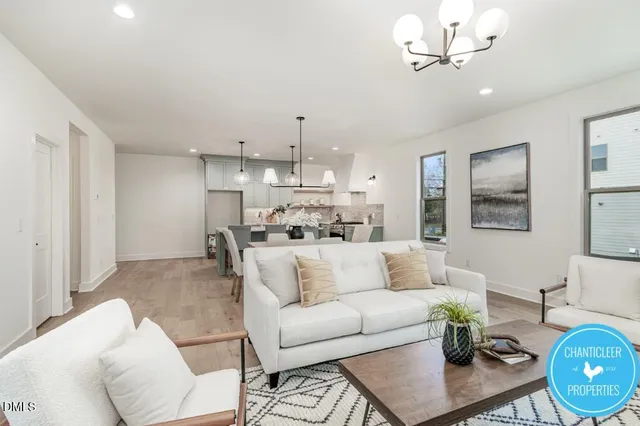 a living room with furniture kitchen and a chandelier