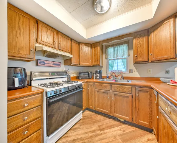 a kitchen with a stove a sink and a window