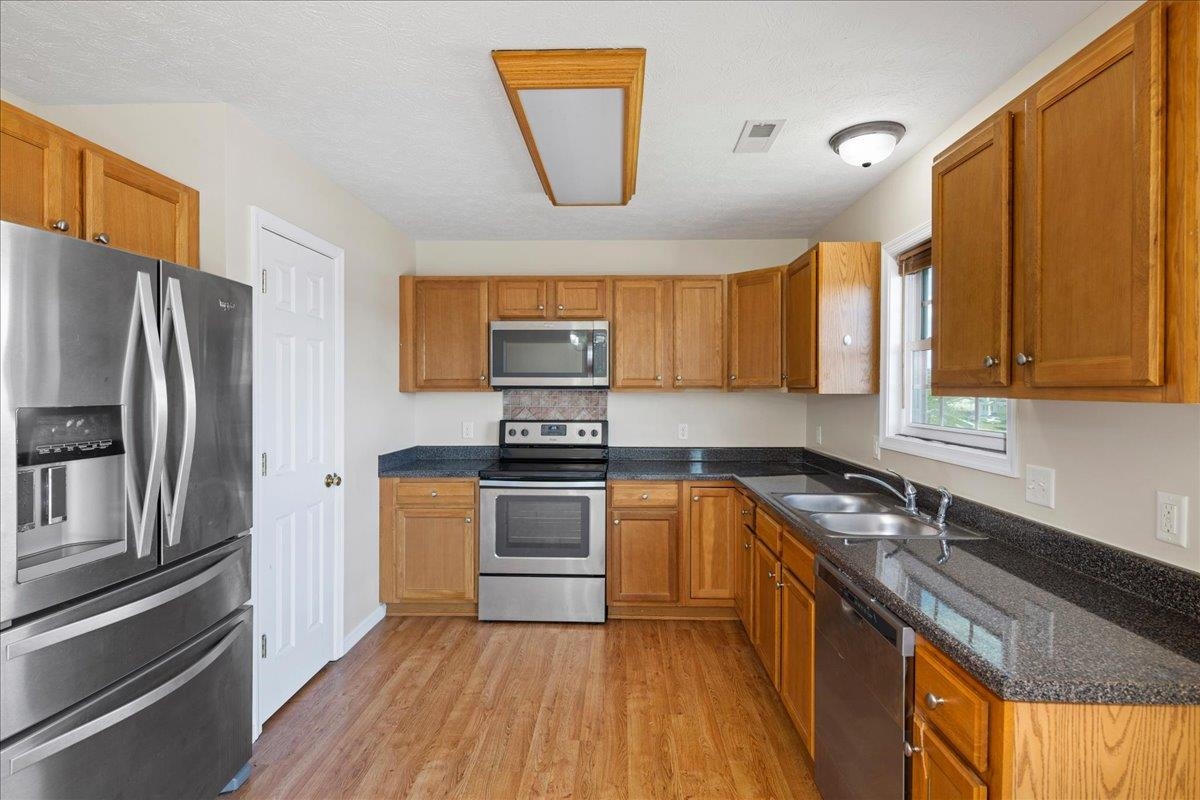 3265 Hebron Court Harrisonburg, VA 22801 - Photo 11 of 30 a kitchen with granite countertop a refrigerator stove top oven and sink