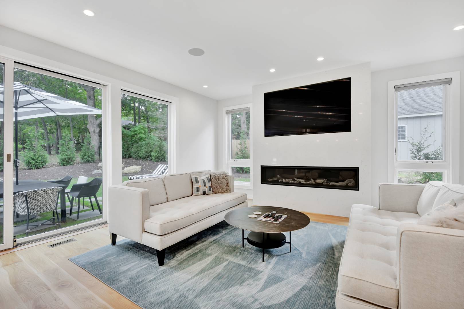 44 Richards Drive Sag Harbor, NY 11963 - Photo 11 of 37 a living room with furniture a flat screen tv and a fireplace