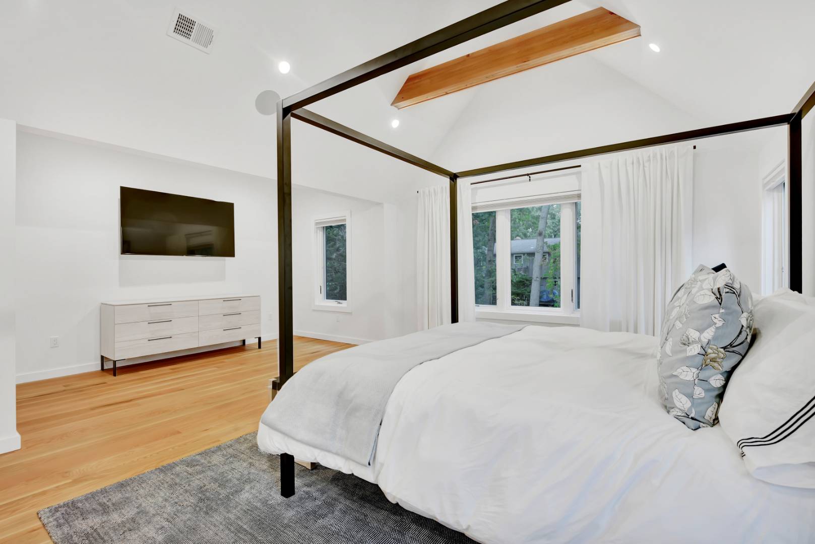 44 Richards Drive Sag Harbor, NY 11963 - Photo 17 of 37 a bedroom with a bed and a flat tv screen on dresser