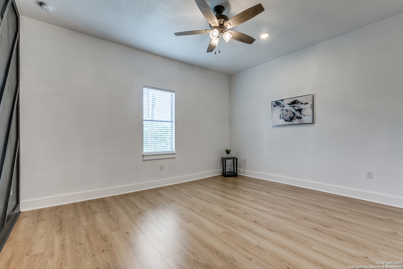 505 Rigsby Avenue San Antonio, TX 78210 - Photo 21 of 29 a view of an empty room with a window and wooden floor