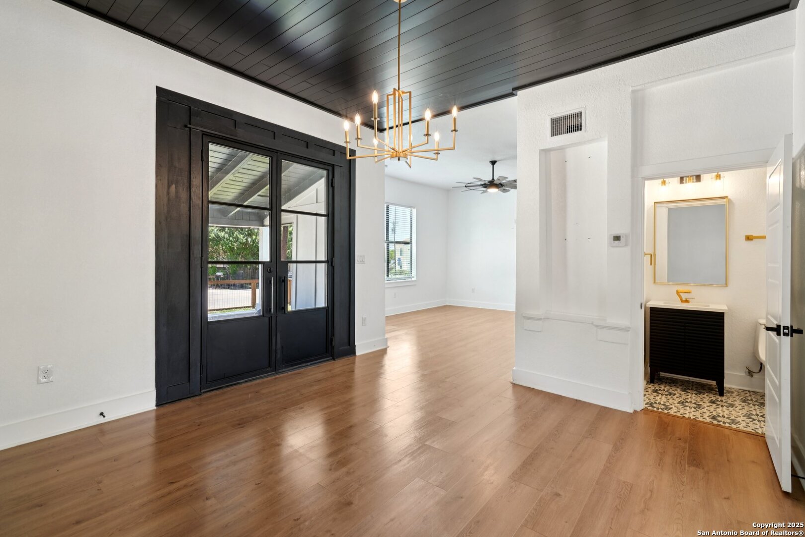 505 Rigsby Avenue San Antonio, TX 78210 - Photo 6 of 29 a view of an empty room with wooden floor and a window