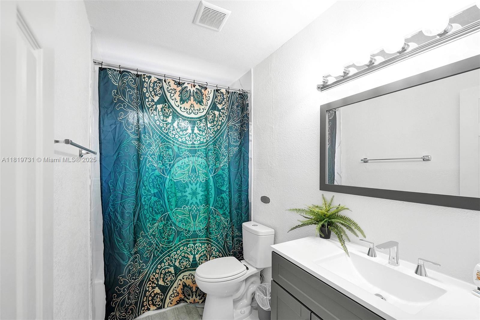 1324 Northeast 151st Street, Unit 1324 Miami, FL 33162 - Photo 16 of 23 a bathroom with a toilet a sink and a mirror
